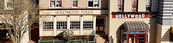 Detailansicht der detailgetreuen Hollywood Street Set-Fassade im Movie Park Germany mit den Schildern "Hollywood Police" und "Hollywood Signs".
